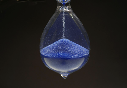Hourglass dripping blue sand